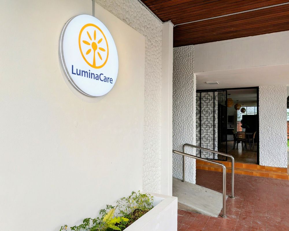 Family visiting a resident in a bright social space at Lumina Care